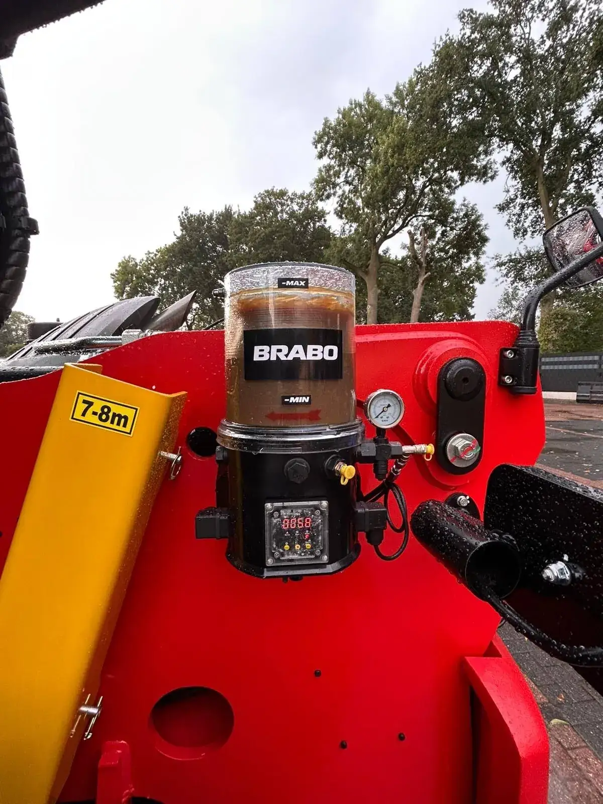 BRABO smeerpomp met vetreservoir gemonteerd op een rode verreiker