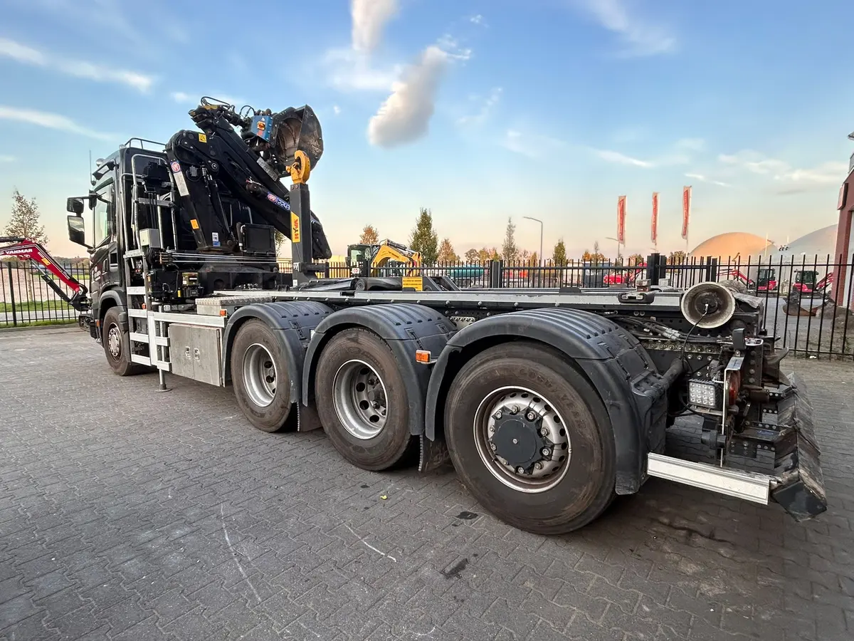 Vrachtwagen met autolaadkraan op een bedrijfsterrein